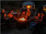 A group gathred around a campfire - thumbnail