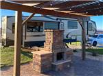 A fifth wheel trailer parked next to a pergolas and fireplace at ANTELOPE POINT MARINA RV PARK - thumbnail