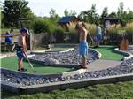 Kids playing miniature golf at Jetstream RV Resort at Stone Oak Ranch - thumbnail