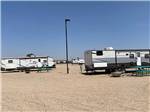 Travel trailers in gravel RV sites at CLOVIS POINT RV STABLES & STORAGE - thumbnail