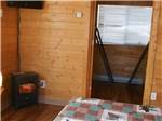 View larger image of A bed and electric fireplace in a cabin at ELLENSBURG KOA JOURNEY image #10