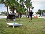 View larger image of A man playing corn hole at QUILLYS BIG FISH RV PARK image #6