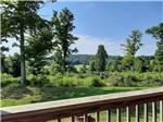 View larger image of View from a deck overlooking green grass and trees at MOUNTAIN TOP RETREAT CABINS  CAMPGROUND image #1