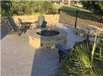 A fire pit with chairs and tables around it at LAKESHORE RV RESORT - thumbnail