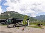 An RV parked with mountains in the background at ALPINE VALLEY RV RESORT - thumbnail