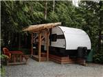 A travel trailer with a table and chairs at SURF GROVE CAMPGROUND - thumbnail