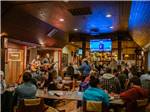 View larger image of A group of people watching musicians perform in the lodge at WHISTLIN JACKS OUTPOST LODGE image #4