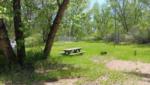 A picnic table and fire pit at a site - thumbnail