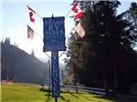 Sign with flags on all sides of it at RIVERHAVEN RV PARK & MOTEL - thumbnail
