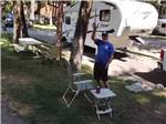 A man waving from his campsite at RIVERHAVEN RV PARK & MOTEL - thumbnail