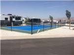 The blue pickleball court next to an RV site at SAND HOLLOW RV RESORT - thumbnail