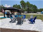 Grey and blue chairs around a fire pit at SOWAL PALMS RV PARK - thumbnail