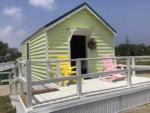 A colorful rental cabin with chairs in the front at ROCKPORT RV RANCH - thumbnail