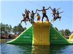 View larger image of People jumping off inflatables at the Aqua Zone at THE SHORES OF ASBURY image #6