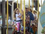 A little girl enjoying the carousel at TRYON INTERNATIONAL RV RESORT - thumbnail