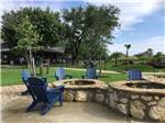 Blue chairs around the fire pits at BUDA PLACE RV RESORT - thumbnail