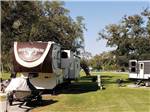 Two fifth wheel trailers in gravel sites at SUGAR VALLEY RV RESORT BY RJOURNEY - thumbnail