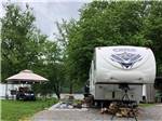 Fifth wheel parked in a gravel site at SPLASH MAGIC RV RESORT BY RJOURNEY - thumbnail
