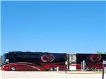 Red and black motorhome with trailer at PORT ST JOE RV RESORT - thumbnail
