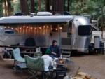 People roasting marshmallows in front of their Airstream trailer - thumbnail