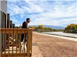 A man and a dog on a deck overlooking the river at CAMP EDDY AND LODGING - thumbnail