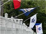 A white fence with flags at BUTTON'S FAMILY CAMPGROUND - thumbnail