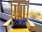 A rocking chair with a pillow that says "Relax" at SAVANNAH LAKES RV RESORT - thumbnail