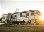 A family outside their parked fifth wheel at GULF SHORES RV RESORT - thumbnail
