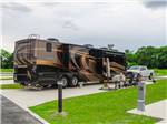 A motorhome parked in a paved site at THE HILL TOP AT BRENHAM RV RESORT - thumbnail