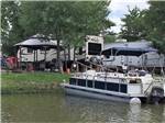 Pontoon boat docked next to RV sites at LAKE CONROE RV CAMPGROUND BY RJOURNEY - thumbnail