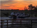 A travel trailer at sunset at YELLOW ROSE RV RESORT - thumbnail