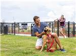 A man petting a dog in the pet area at LOVE'S RV STOP - 801 - thumbnail
