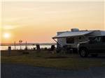 A travel trailer parked under the sunset at SUN OUTDOORS CHINCOTEAGUE BAY - thumbnail