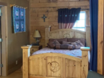 Cabin interior with wood bed frame at 	A Peace of Heaven Cabins and RV Park - thumbnail