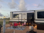 Camper with red chairs outside at Beach Road RV Park - thumbnail