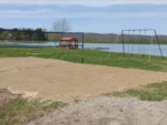 Volleyball Court at waterfront at Country Charm Campground - thumbnail