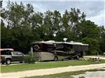 A motorhome and truck in a site at MIDPOINT I-95 RV PARK - thumbnail
