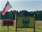 Entrance sign with red arrow and American flag at Midpoint I-95 RV Park - thumbnail