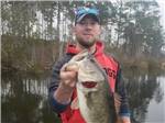 A man showing a fish he caught at DREAM RV PARKS - thumbnail