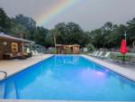 The pool area at dusk with a rainbow at VACAY VILLAGE OF PENSACOLA - thumbnail