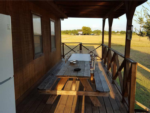 Wooden table on a wooden deck at M Bar H Lodge and RV Park - thumbnail