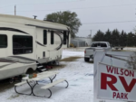 Snowy RV site with picnic table at Wilson RV Park - thumbnail