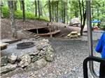 A fire pit next to a tent site at PLUMTREE CAMPGROUND AND RETREAT - thumbnail