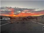 RVs parked in gravel sites at sunset at WHISTLESTOP LUXURY RV PARK - thumbnail