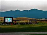 Guest watching a large screen movie outside at INDIAN SPRINGS RANCH GOLF & RV RESORT - thumbnail