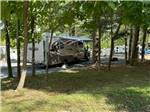 A travel trailer in a shady spot - thumbnail