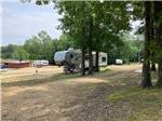 A fifth wheel trailer parked in a gravel site at CORINTH RV PARK - thumbnail