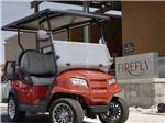 A golf cart parked in front of the pool house at FIREFLY LUXURY RV RESORT - thumbnail