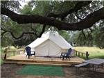 A glamping tent with lounge chairs in front of it at REBECCA CREEK CAMPGROUNDS - thumbnail