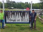 Two men standing by a sign with the fish they caught at BELLS MARINA RV RESORT - thumbnail
